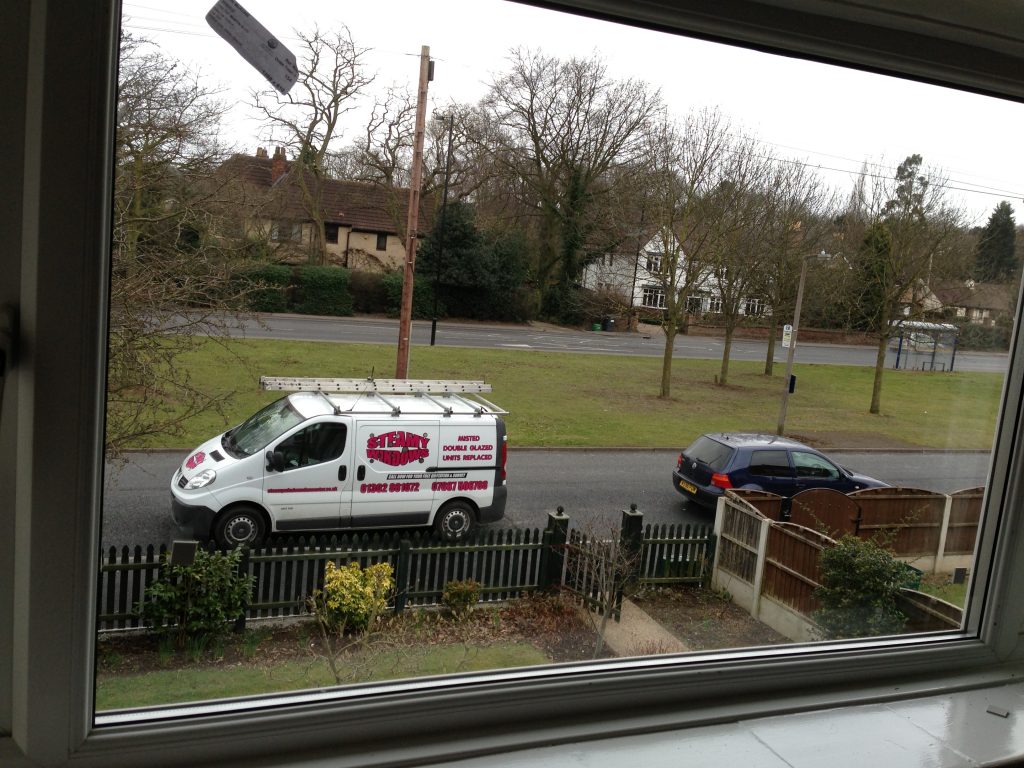 The same Steamy Windows van on the same Doncaster street, seen sharply through clear double glazing